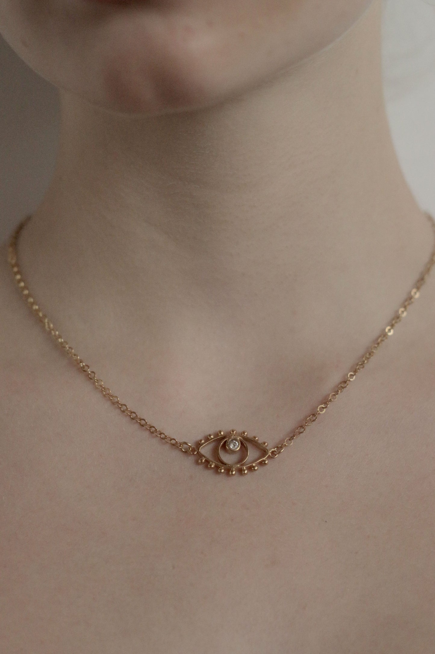 gold eye necklace on model
