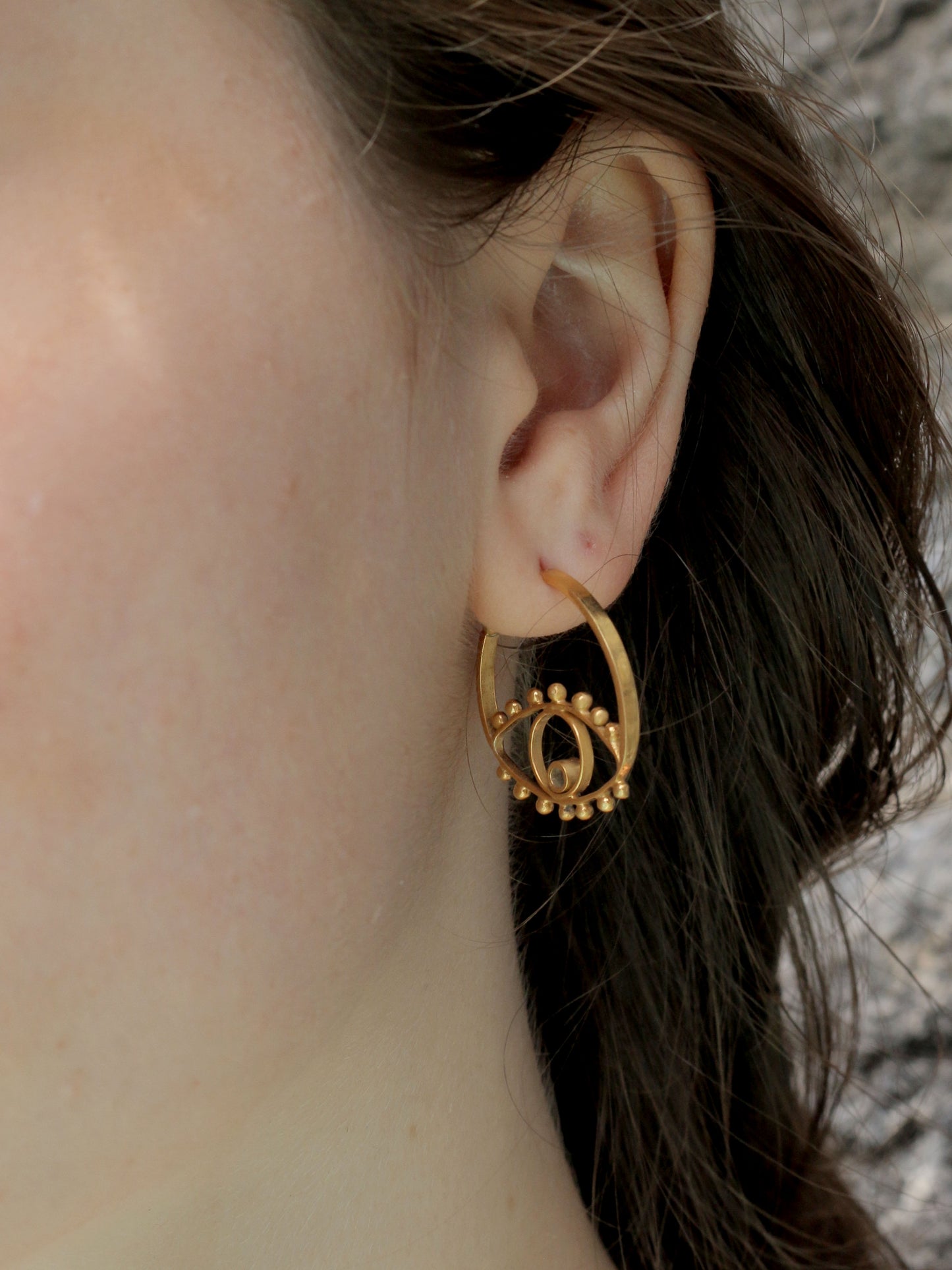 gold circle eye earrings close up