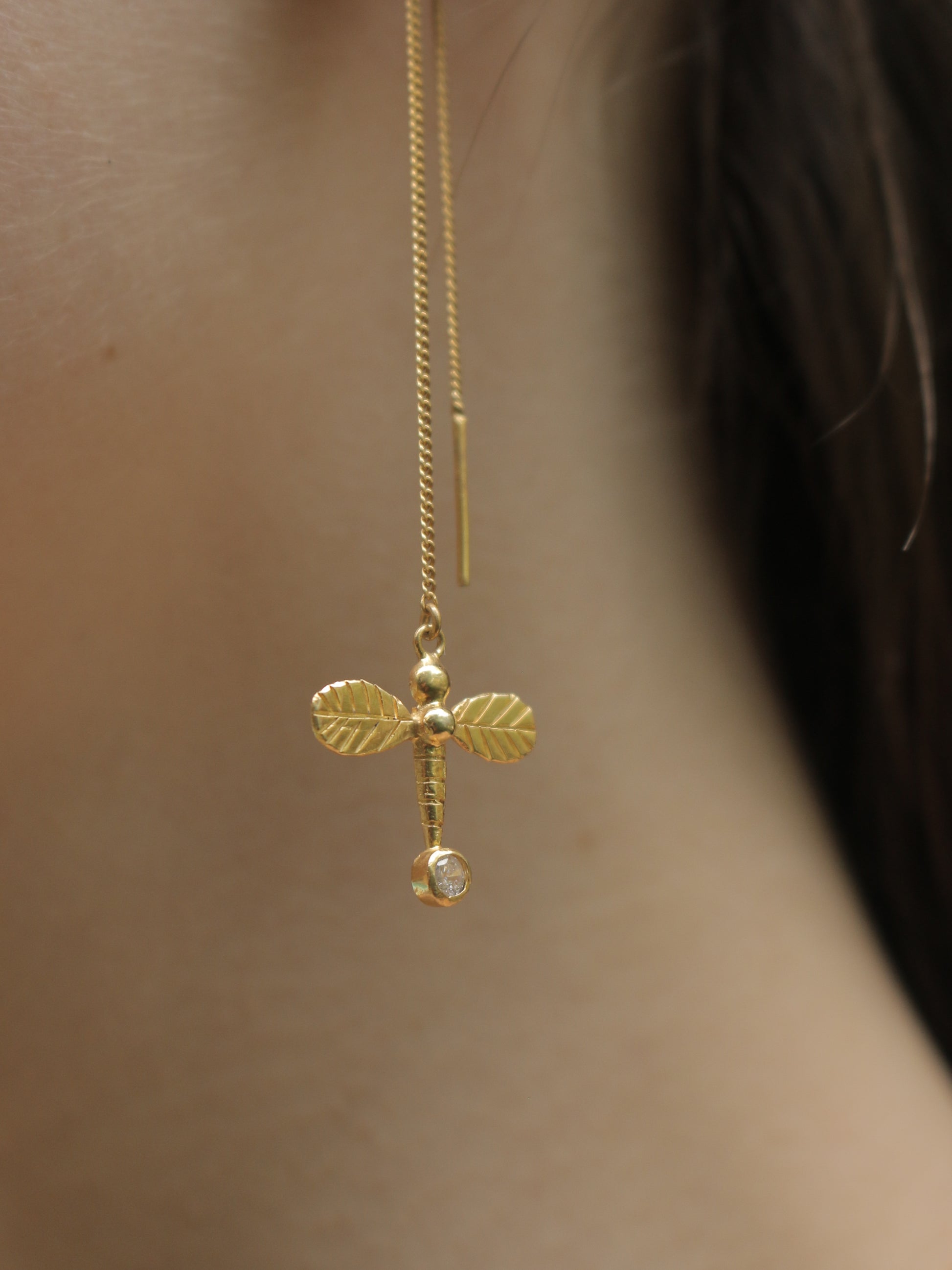 Dragonfly gold earrings close up photo